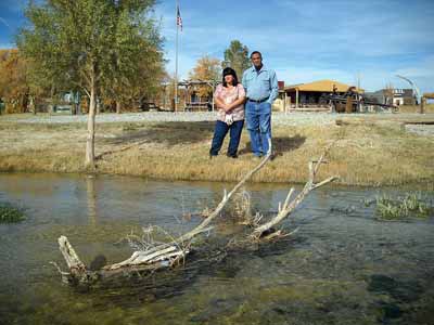 Victor and Annette Fuentes next to stream when it ran through their church camp. (Photo by Mark Waite, Pahrump Valley Times)
